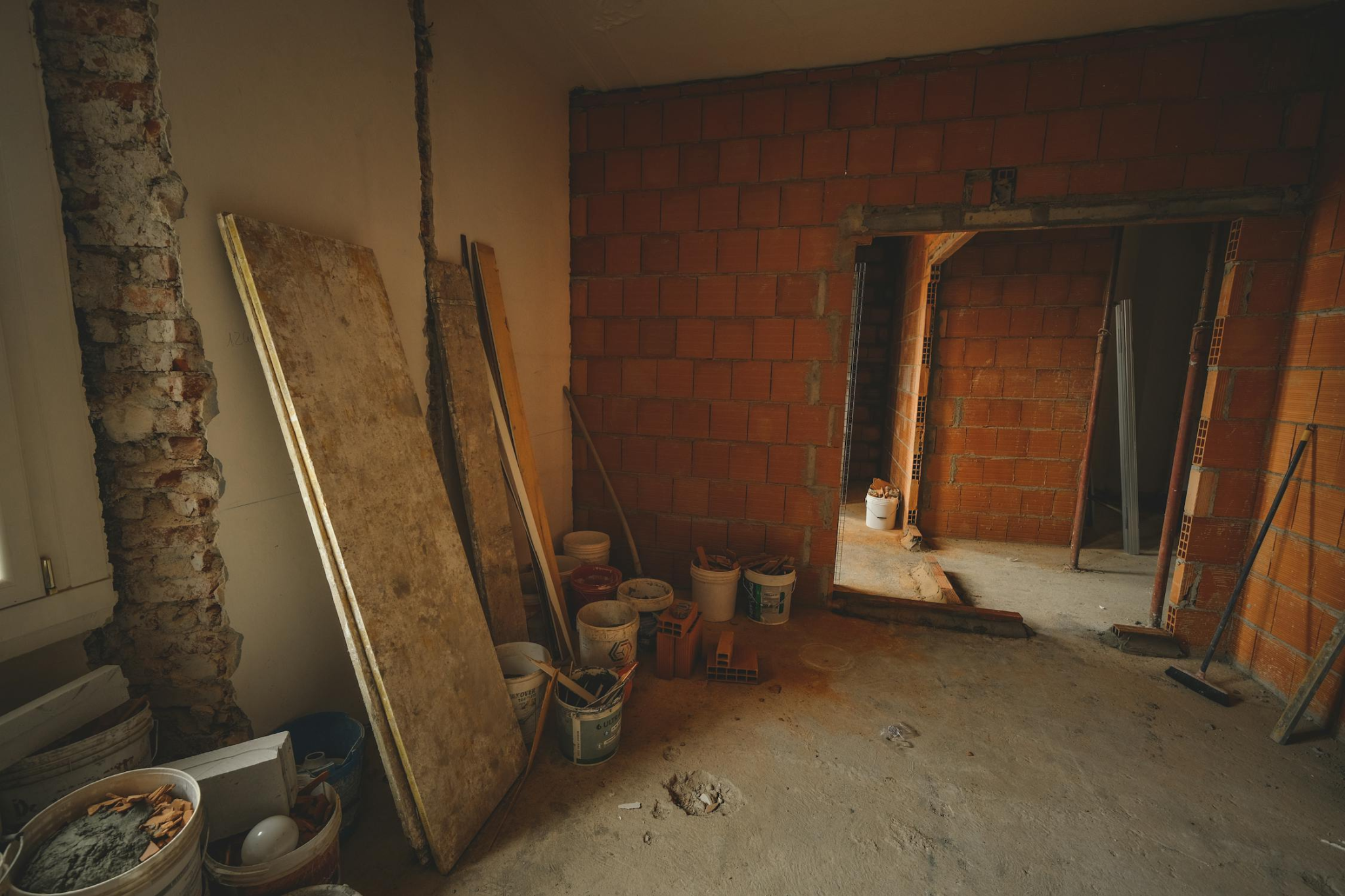 An unfinished room with exposed brick walls and a concrete floor