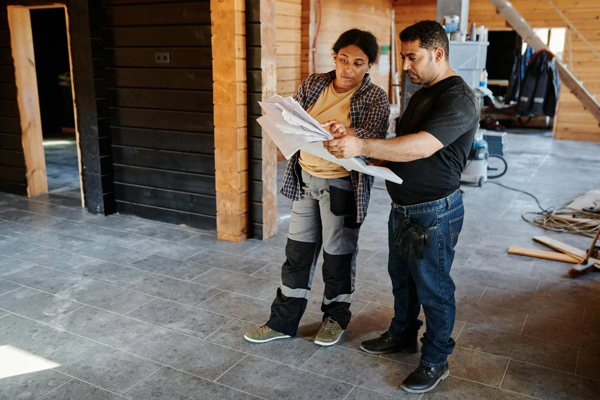 Two construction workers standing in an unfinished building