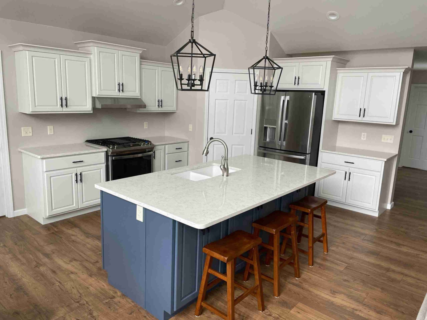  A beautiful white kitchen can be seen on wooden flooring
