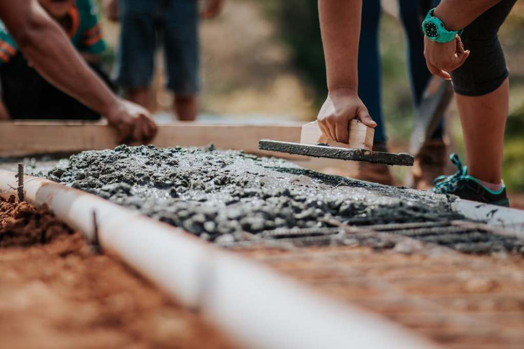 An image of people setting cement in a mold