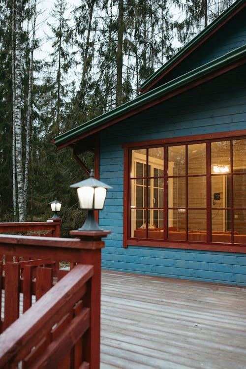 An image of a house’s deck with attached lamps on the railing corners.