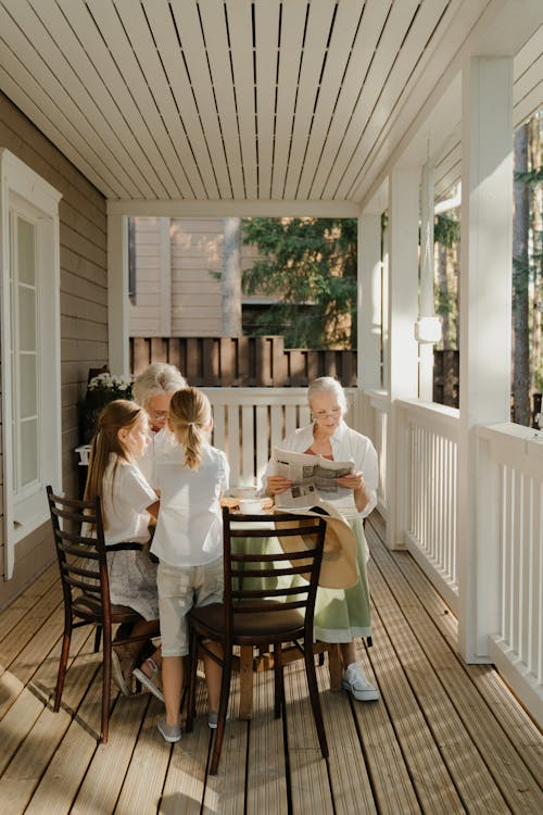 An image of a family sitting around a table on their house’s deck.