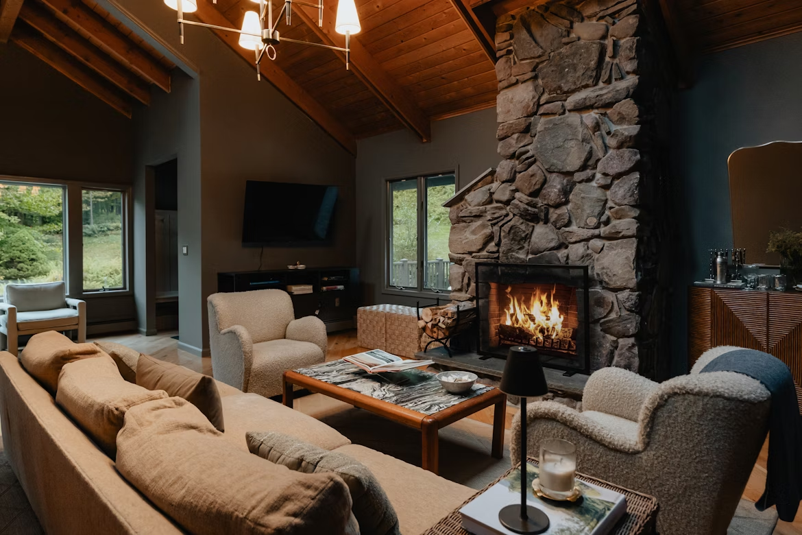 A cozy cabin living room with couches and a fireplace.