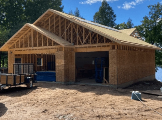 New home under construction with exposed wooden framing and attached garage in Rhinelander
